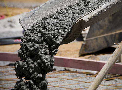 Concrete pouring from a truck to for the construction of a new floor. Motion blur on the moving concrete. industrial, foundation, floor, concrete, pouring, motion blur, construction, heavy, pouring, new, fresh, wet, movement, building, vignette, architecture, outside, building interior, new home