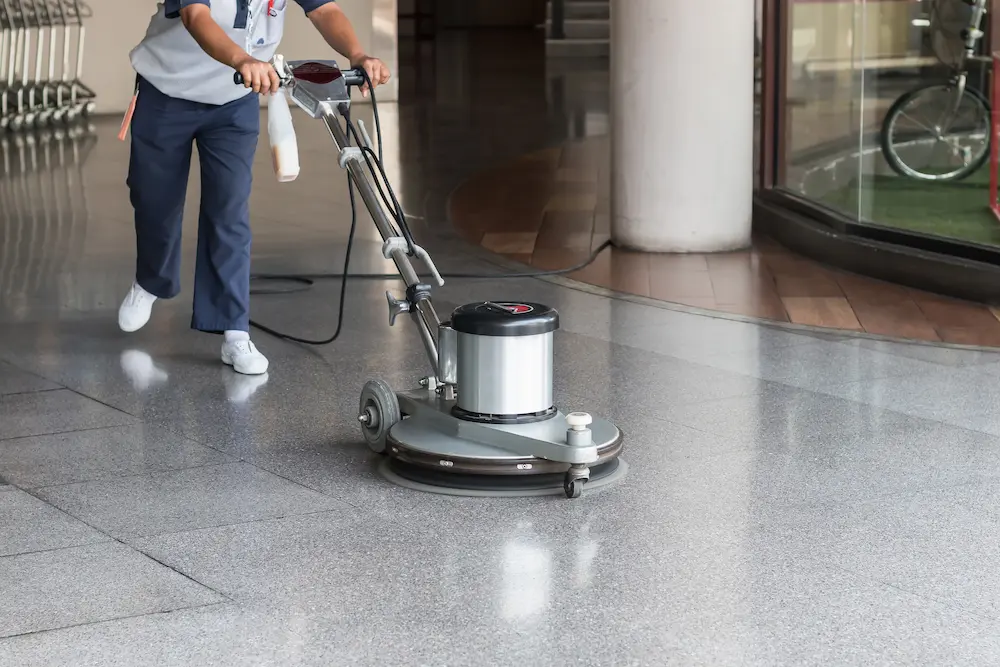 Persona aseando el piso con una brilladora industrial